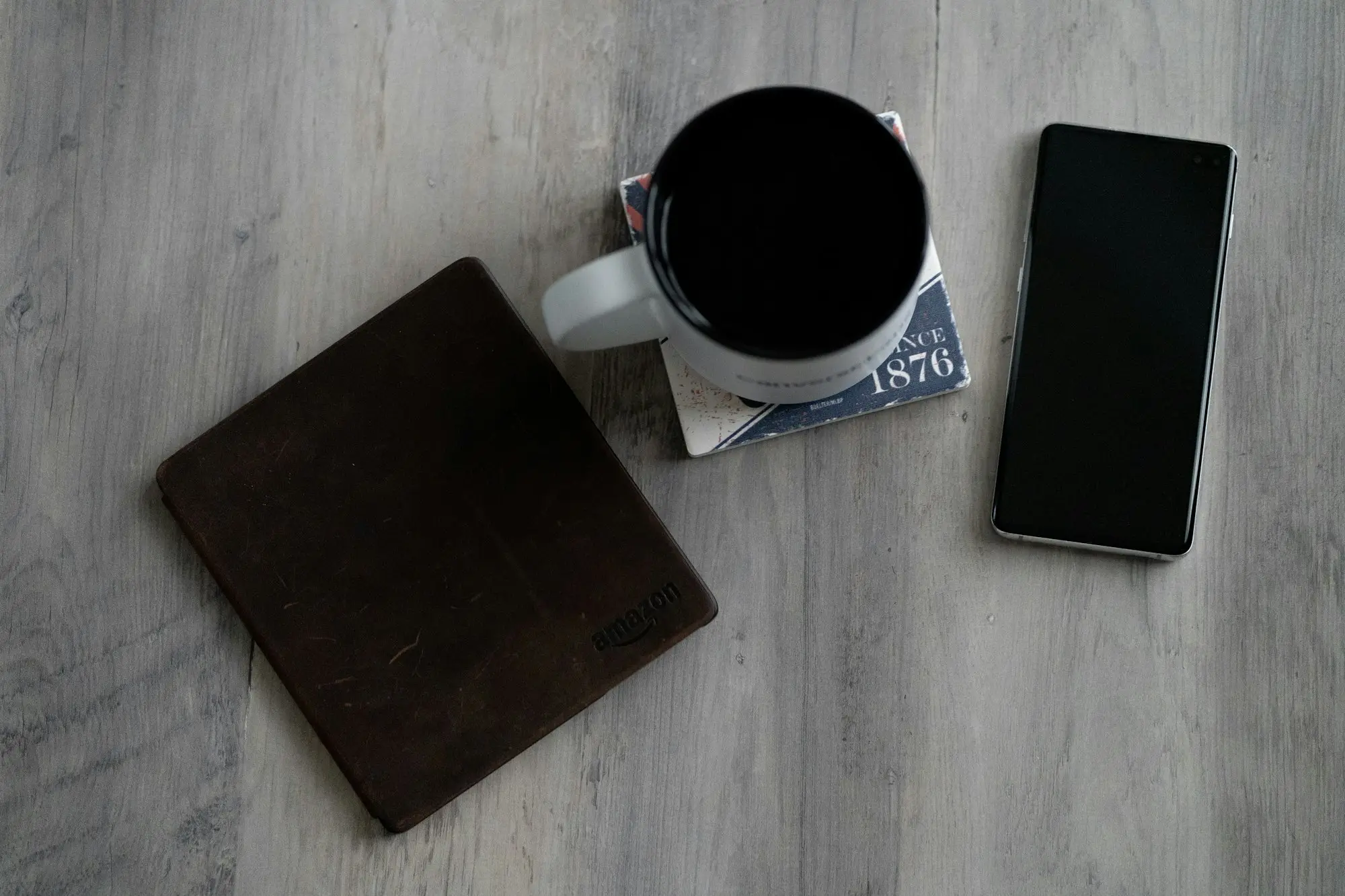 Mug, wallet and smartphone on a desk
