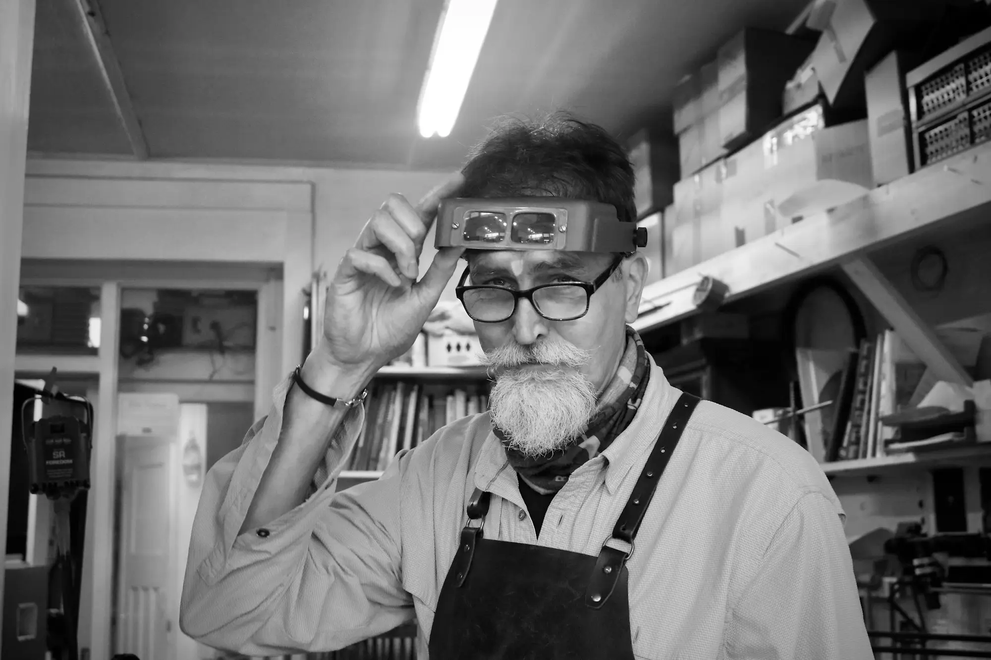 Workshop owner adjusting his magnifying headband